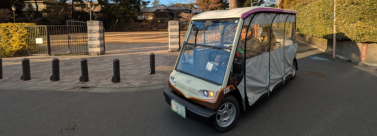 街中を走るグリーンスローモビリティの写真